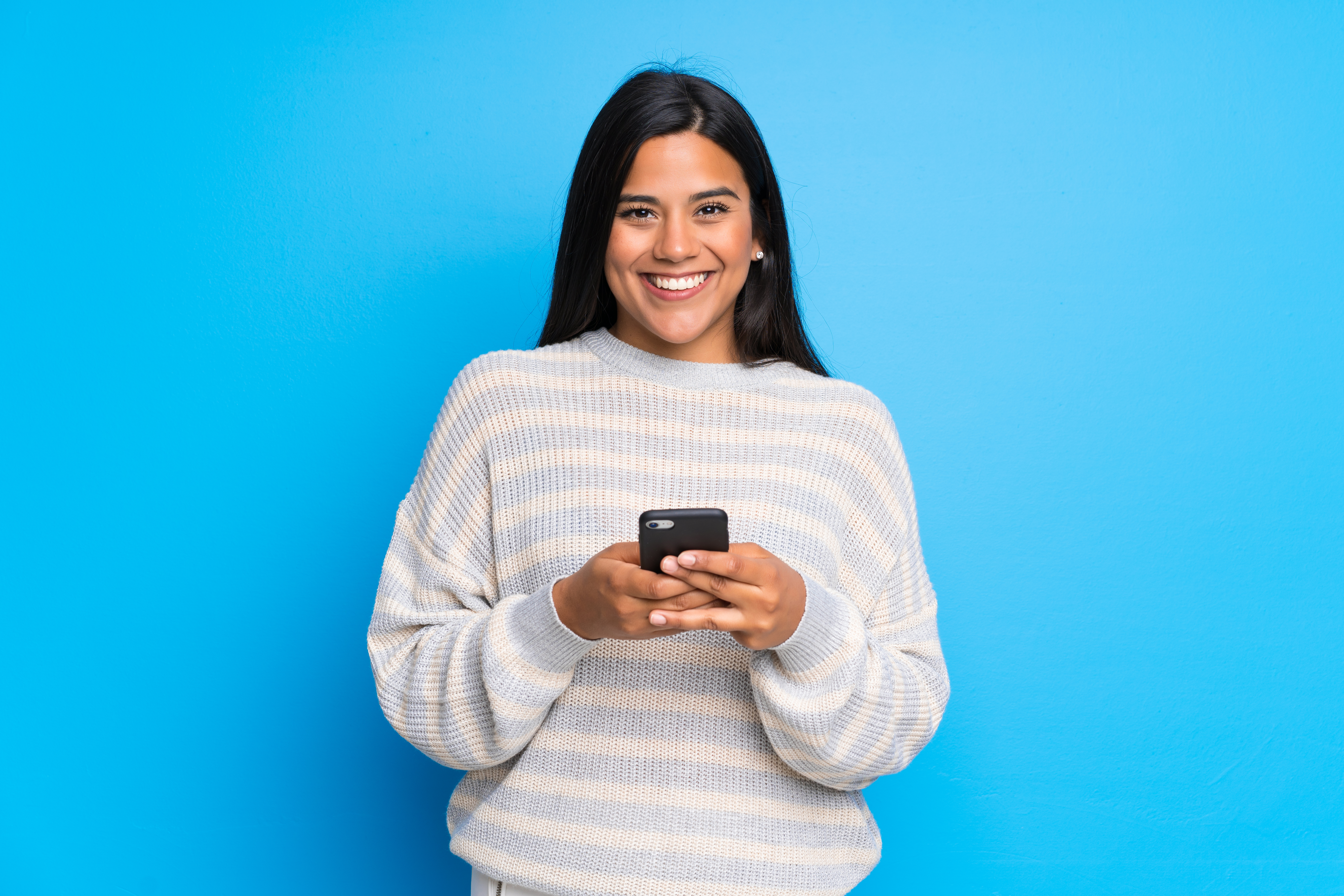 Woman holding smart phone and smiling