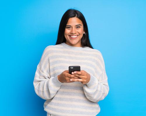 Woman holding smart phone and smiling