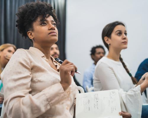 group of people seated and taking notes