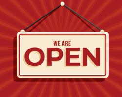 "We're Open" sign hanging on a red sunburst background