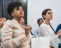 group of people seated and taking notes