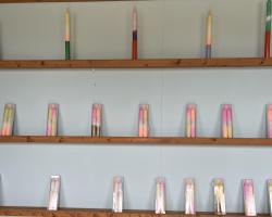 Colourful tapered dip dye candles on shelves