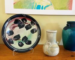 photo of ceramic plate and vase displayed on a shelf.